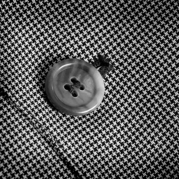 Dark grey formal suit lapel with button hole. Close up.