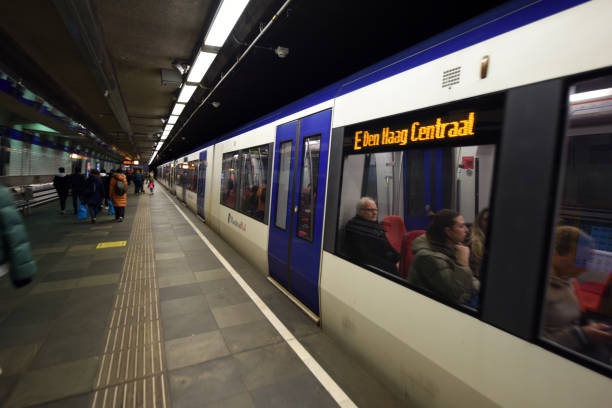 The Wilhelminaplein metro station in Rotterdam City with several people next to a departing subway train.