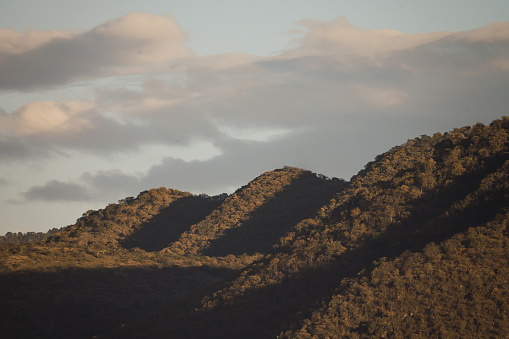 Mountains of the Sierra de Michoacan at sunset, with the sunlight hitting them from the side.
