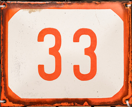Red and white weathered grunge square metal enameled plate of number of street address with number 33
