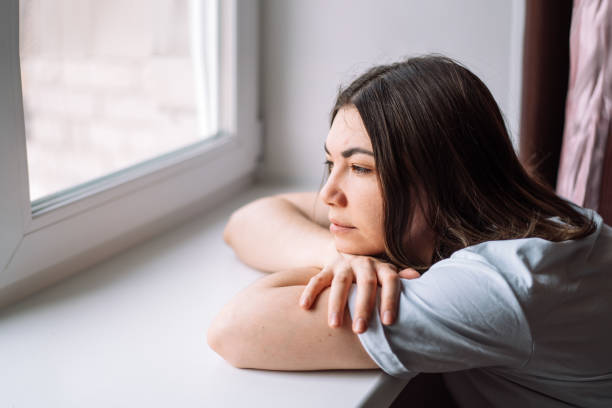 istock Lady lay down on the windowsill and looks out the window 2040696902