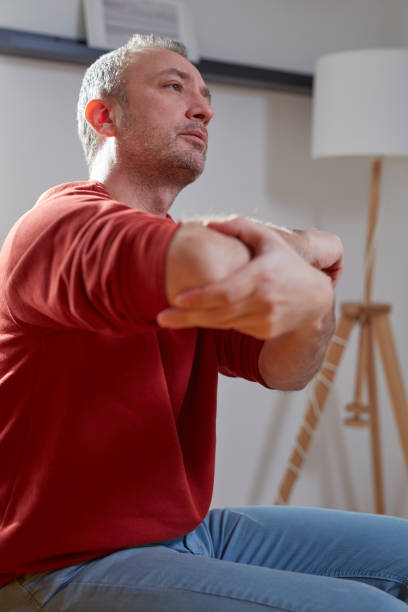 istock Man with elbow pain at home. 2040697381