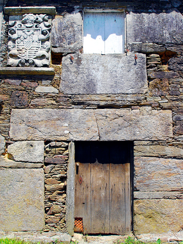 A wooden door in an old stone building.