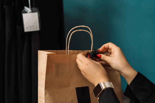 istock Lady hanging a black bow on a paper bag indoors 2040707093