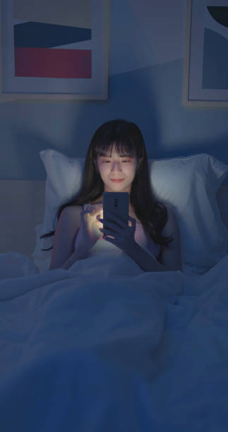 istock Asian woman scroll smartphone dark 2040711948