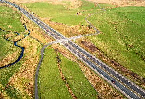 A country road crossing over a two lane dual carriageway in Ayrshire, Scotland.