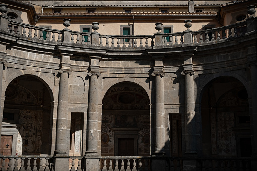 Facade of the Cathedral de Santa María la Mayor in Cuenca, Spain. Several people are passing by or sitting on the stairs. Sunny weather. 