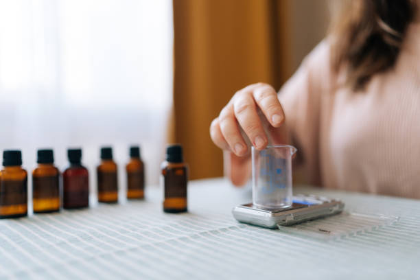 istock Close-up hands of unrecognizable artisan preparing using of scented perfume for creating candle building mixture. Process of making handmade natural scented candle 2040734134