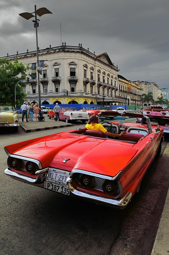 Havana, Cuba-October 07, 2019: Red oldtimer American classic car -almendron, yank tank- Ford Thunderbird 2 door Convertible from 1959 stops on the Paseo del Prado promenade, Parque Central Park area.