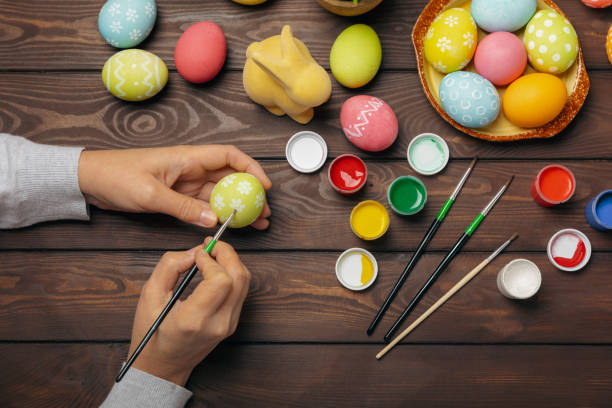 istock Easter egg painting at the kitchen table.Happy Easter celebration concept.Colorful Easter eggs with different patterns.Paints,decorations for coloring eggs for holiday.Creative background.Copy space 2040758802