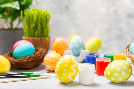 Easter egg painting at the kitchen table.Happy Easter celebration concept.Colorful Easter eggs with different patterns.Paints,decorations for coloring eggs for holiday.Creative background.Copy space
