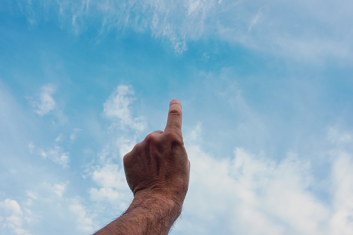 man hand gesturing on the blue sky
