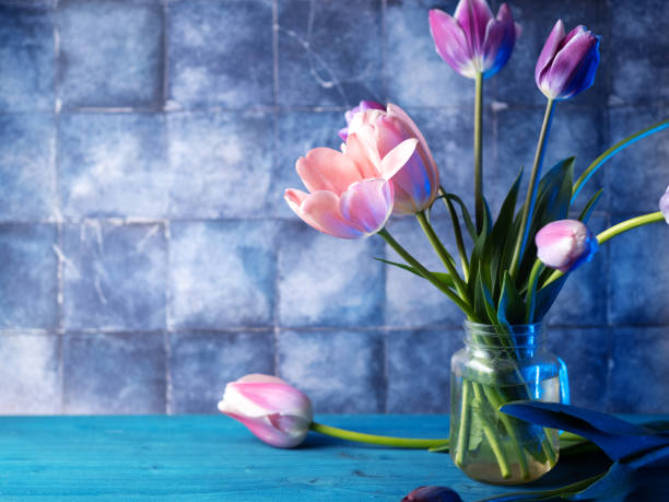 bouquet of tulips on a blue table. Copy space.