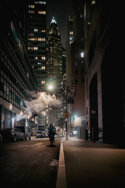 New York, USA. November 12, 2019. Pedestrian crossing shrouded in subway steam. People on 5th Avenue at the intersection with 38th Street.