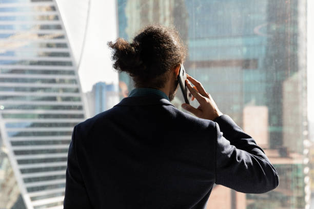 istock Confident young african businessman talk on phone by office window 2040824310