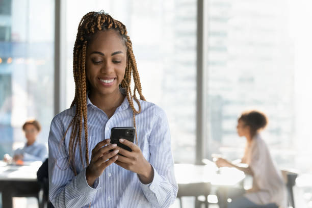 istock Smiling biracial female manager use phone at work text message 2040830154