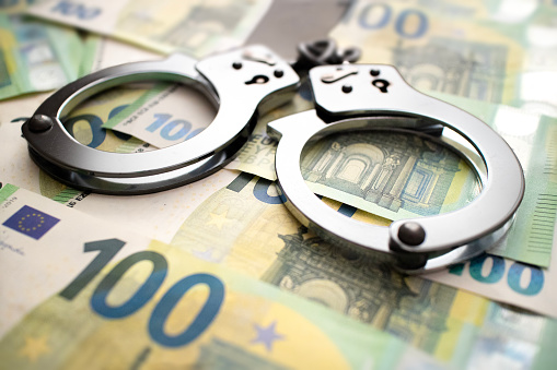 Handcuffs lie on 100 euro banknotes