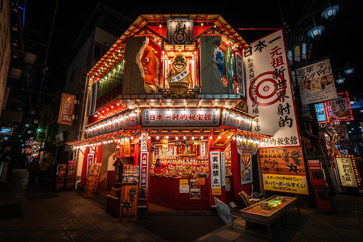 Osaka, Japan - December 7, 2023: Shooting gallery illuminated at night in the Shinsekai New World district of Osaka, Japan.