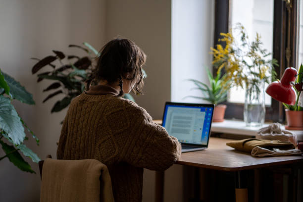 istock Clever diligent concentrated schoolgirl sitting at desk, studying, reading, doing homework on laptop 2040848147