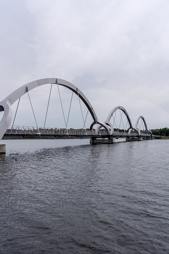 An arched bridge over water under a cloudy sky, Sweden, Soelvesborg