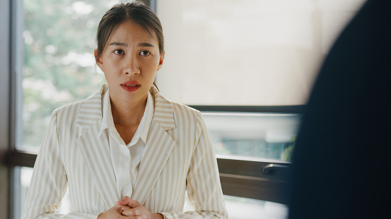 Angry Asian businessman arguing with businesswoman about paperwork failure disputing having conflict confrontation at office. Businesspeople in workplace.