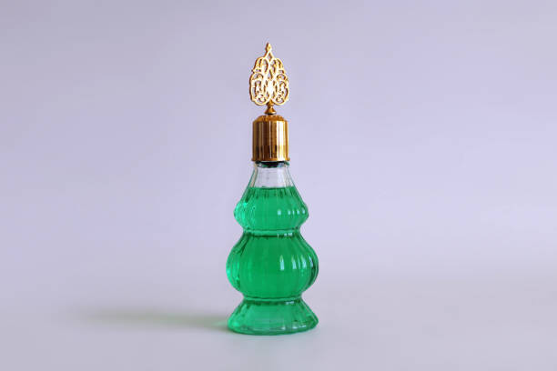 Infused olive oil of diverse colors with various herbs in small bottles with cork taps on glass shelves on display, close-up