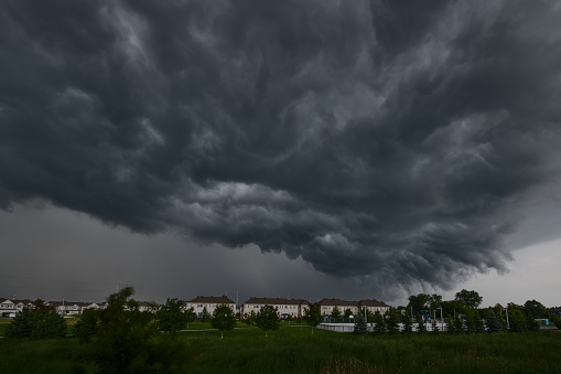 A large ominous dark cloud looms over the cityscape