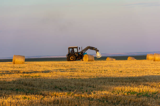 istock Tractor collecting round stacks of straw 2040876205