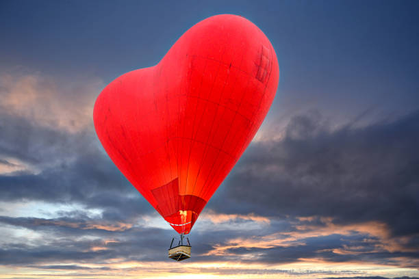istock Beautiful heart-shaped hot air balloon flying at sunset 2040876207