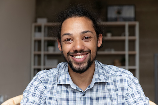 Head shot happy millennial generation African American bearded man looking at camera, holding pleasant distant video call conversation, passing job interview remotely, web camera screen view.