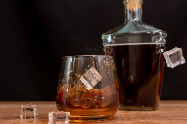 ice cubes falling into a glass of whiskey - whisky glass ice cube alcohol ストックフォトと画像