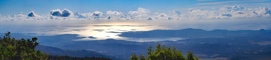 At sunrise, panoramic view of the eastern coast of Corsica, nicknamed the Isle of Beauty, from the charming belvedere village of Prunelli. We see a large part of the plain, the island of Elba and Montecristo. On a clear day mainland Italy can be seen
