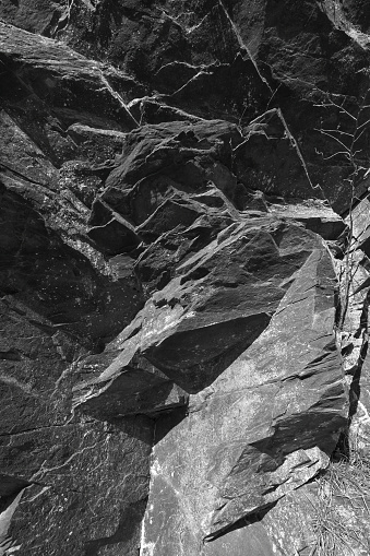 Vertical close-up of schist outcrop on the eastern slope of Mount Tom in Connecticut, where the rocks have been estimated to be 1.3 billion years old. Black and white photo. Schist is a metamorphic rock, formed from tremendous pressure and heat. It constitutes much of the bedrock in this area. This rock is similar to the Manhattan schist found in New York City's Central Park.