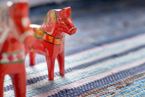 Hand-made traditional wooden Dala  Horse. Traditional handmade carpet, hand woven rug