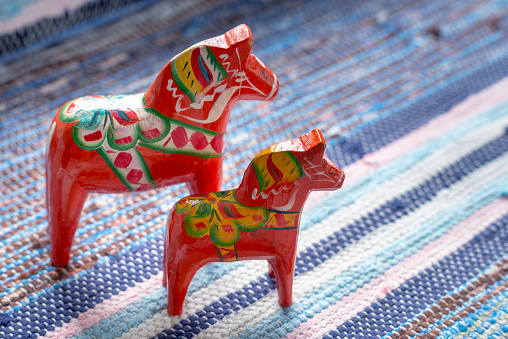 Hand-made traditional wooden Dala  Horse. Traditional handmade carpet, hand woven rug