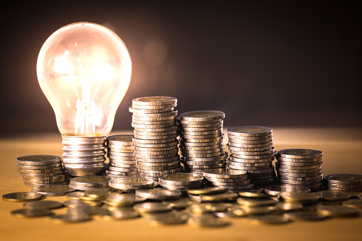 Stack of coins and light bulb for saving money concept, Creative ideas of business planning, success in the future.