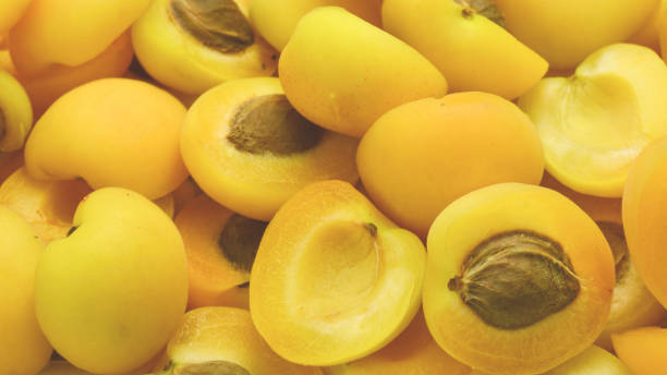 istock Ripe juicy orange apricots slices fruit background. 2040934733
