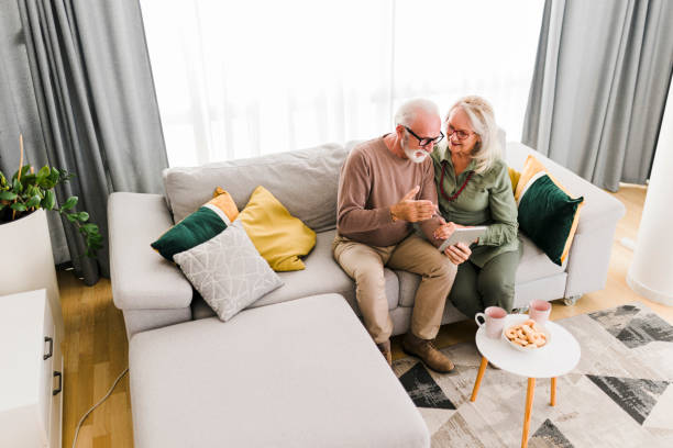 istock Senior retired couple using digital tablet and enjoy talking conversation together on sofa with happiness laugh smile and joyful at home 2040952763