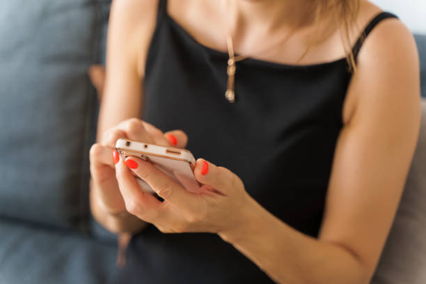 istock A woman using a smartphone presses her finger, reads social networks on the Internet, types text or shops online. Mobile phone in two black hands 2040953811