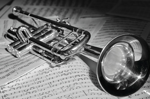 A view of the musical instrument which is the trumpet against the background of the sheet music