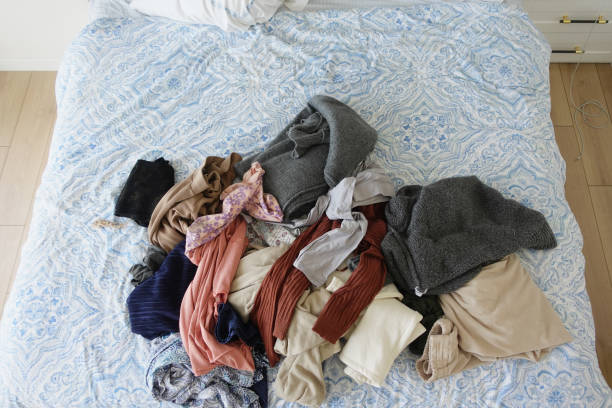 istock messy bed with cloths in early morning , messy bed after waking up 2040981145
