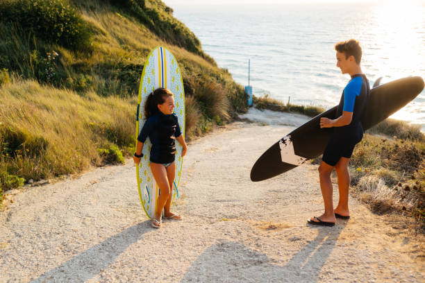 adolescentes se preparando para surfar na praia - surfing teenage girls friendship sunset - fotografias e filmes do acervo