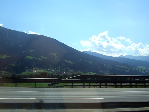 A view of the mountains from a car on a fast-moving road. Natural picturesque landscape under the bright sun