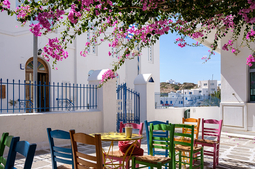 View of a bar restaurant with a picturesque terrace outdoors and colorful chairs in Ios cyclades Greece