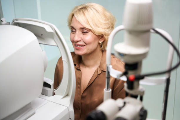 istock Smiling woman sits in front of a special ophthalmic device 2041017109