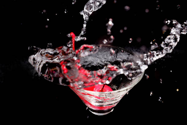 istock liquid splashing into a glass with cherries in a black background. 2041041131