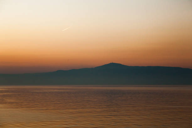 Sea and mountains horizon during sunset at dusk.