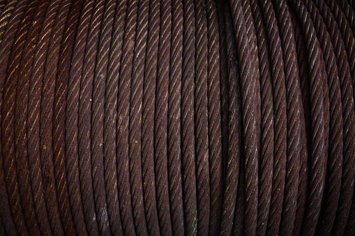 Steel twisted cable wound on a drum, next to each other, close-up.