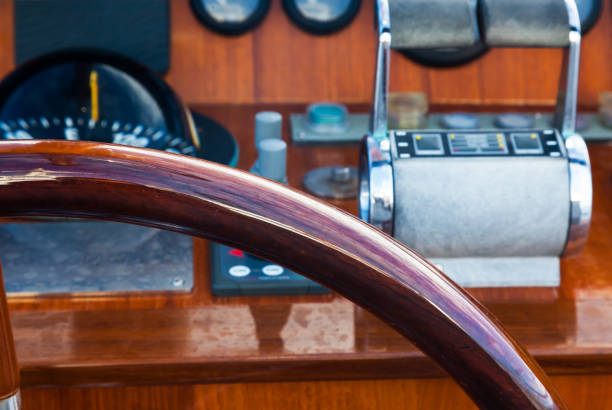 Motor yacht control panel. Steering wheel, gear levers, gauges, speedometers and control buttons.