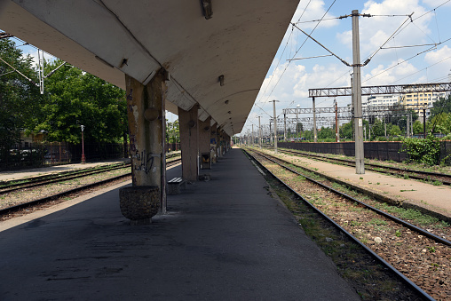 At București Basarab Railroad station. The image shows the station platform and railway tracks, captured during a cloudy day in summer.